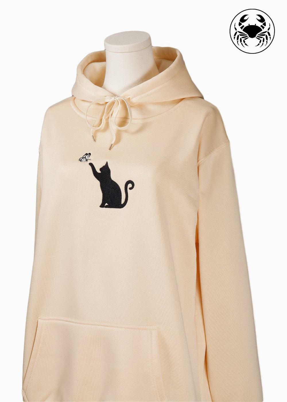 Unisex light beige hoodie with a front kangaroo pocket, drawstring hood, and an embroidered chest design featuring a black Cat Caught in a Moment with Butterfly