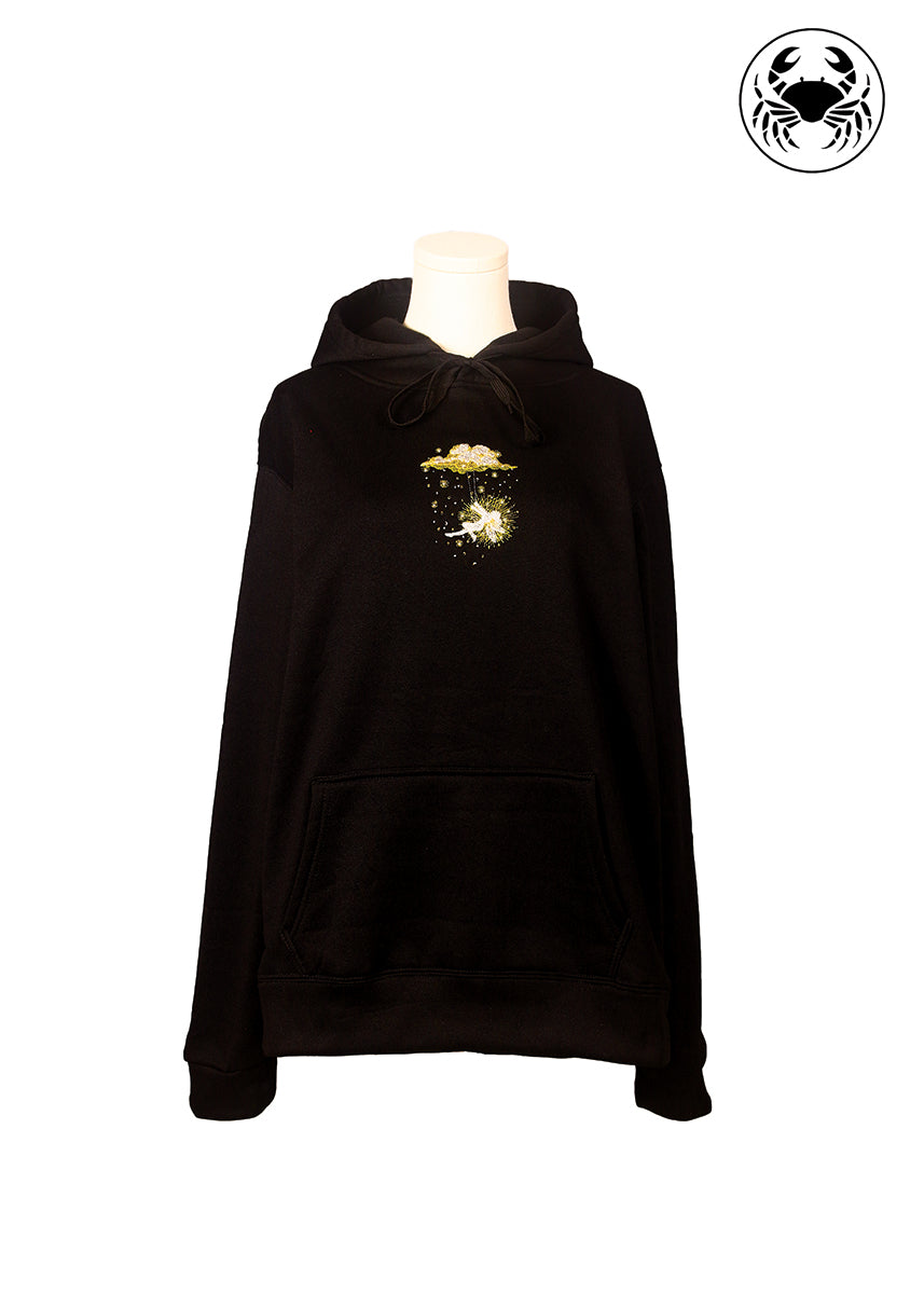 Front view of black hoodie with golden embroidered fairy swinging beneath a glowing cloud, Canadian apparel