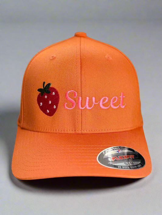 Orange hat with embroidered strawberry and the word “Sweet” in pink thread on the front